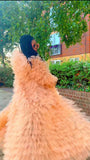 Person wearing a peach feathered dress with a blurred background