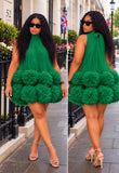 sleeveless tulle dress with a tiered, fluffy pom-pom hem, shown in a side-by-side front and back view on a city sidewalk.