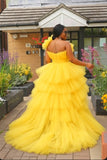 Back view of yellow tiered tulle gown with voluminous layers and flowing train